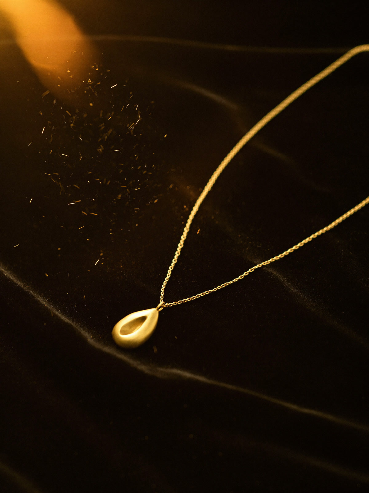Study of a gold pendant on dark velvet